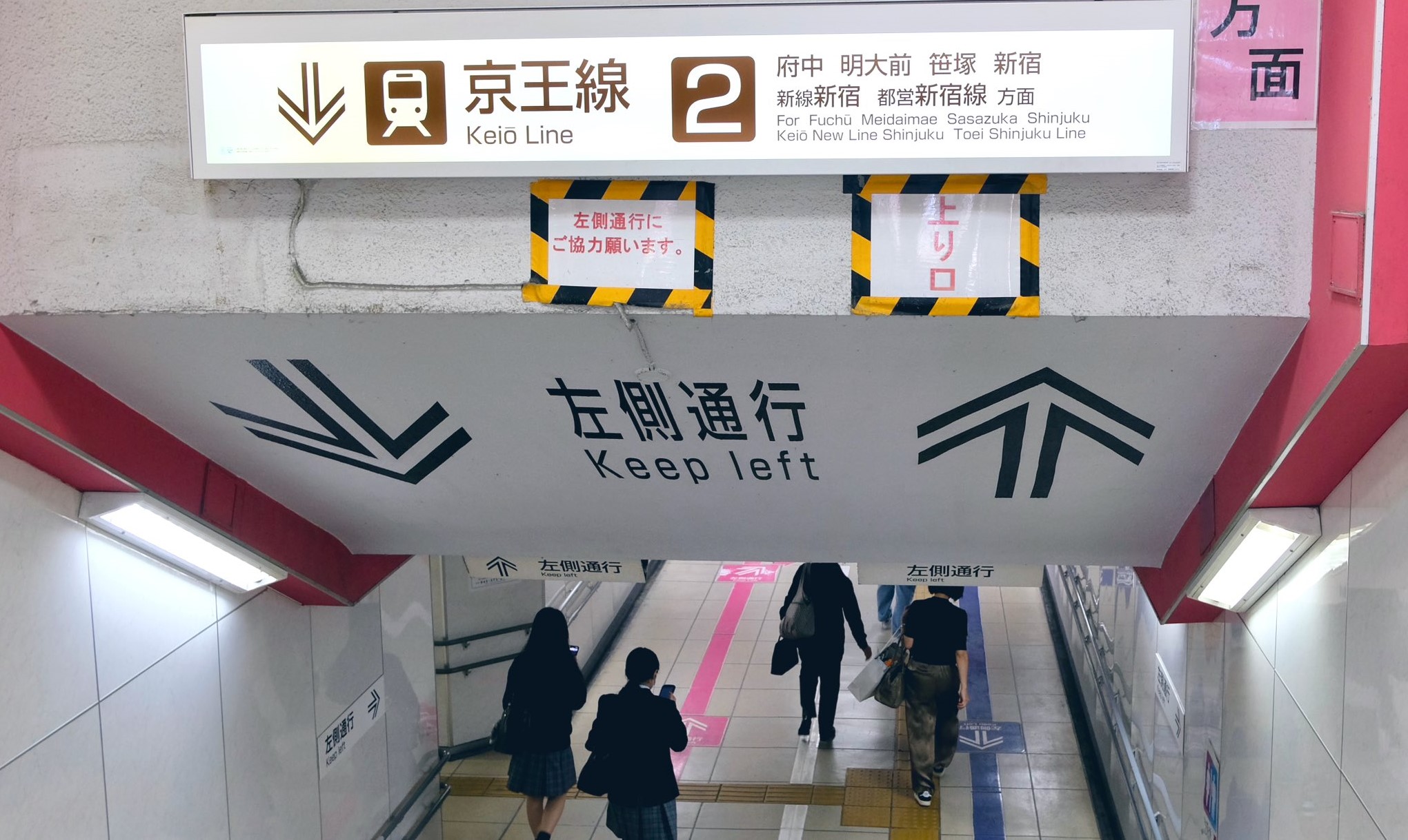 Wayfinding signage underfoot & overhead at stairs at Japan rail station. Haco